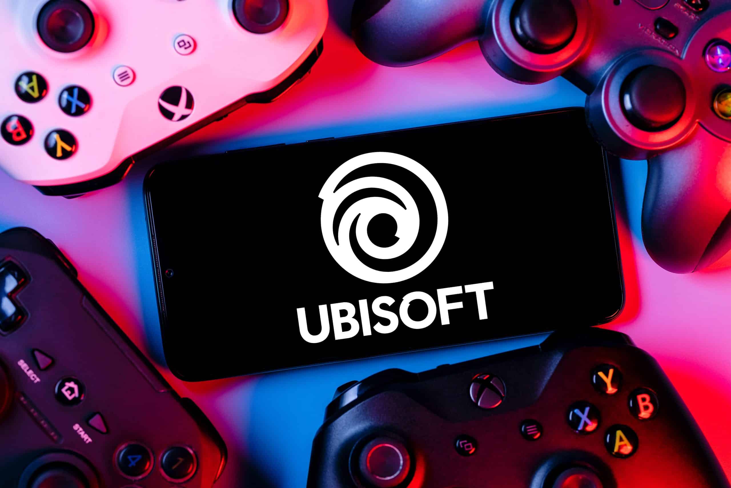 Ubisoft logo on a phone next to controllers