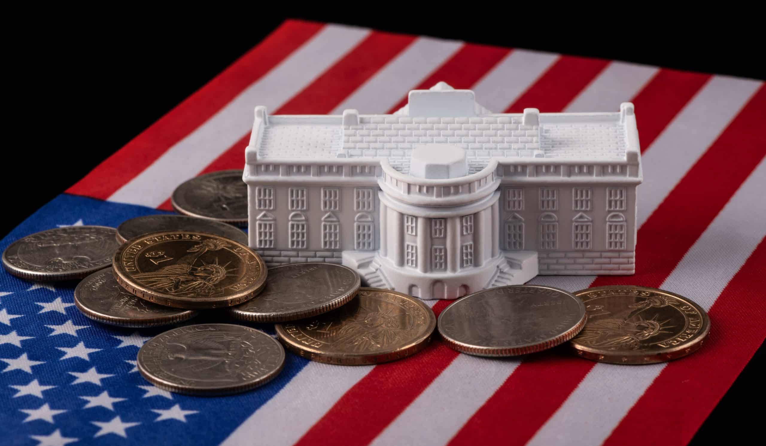 White House figurine with coins and American flag